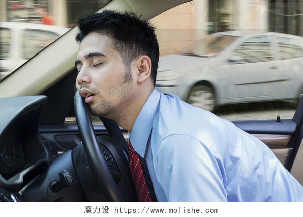 在拥堵道路上驾驶汽车时睡在车上的年轻商人疲劳驾驶疲劳犯困